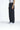Person, die 2Y Studios Anela Worker Baggy Jeans in verwaschenem Schwarz von 2Y Women trägt, dazu ein weißes bauchfreies Top und weiße Sneakers, und vor einem schlichten Hintergrund steht.