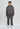 Eine Person in einem grau gewaschenen LowLights Men Basic Zip Hoodie und passender Jogginghose mit weißen Turnschuhen blickt nach vorne, vor einem schlichten hellen Hintergrund in den Low Lights Studios.