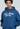 Eine Person, die den LowLights Men LowLights Shutter Zip Hoodie in Marineblau trägt, auf dessen Vorderseite "Low Lights Studios" in Schreibschrift steht.