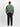Eine Person steht mit dem Gesicht nach unten und trägt eine Alpha Industrie Ma-1 Heritage Vintage Green Jacke, eine schwarze Hose und schwarze Schuhe vor einem schlichten weißen Hintergrund.