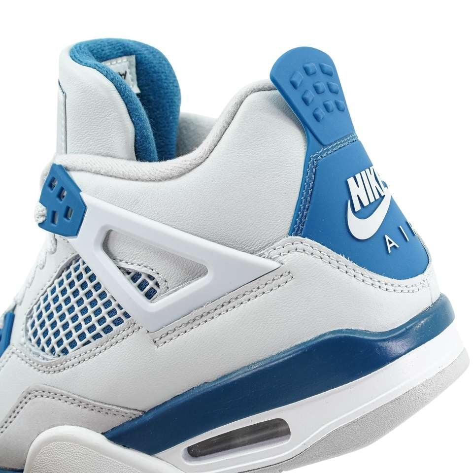 Nahaufnahme eines weiß-blauen Nike Air Jordan 4 Military Blue (GS)-Sneakers, bei dem die Knöchelstütze, das Mesh-Panel und das markante Fersenlogo hervorgehoben werden.