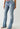 Person, die True Religion I Love True Becca Mr Boot Cut Peak Spot Jeans trägt, mit offenen Sandalen, vor einem schlichten hellen Hintergrund.